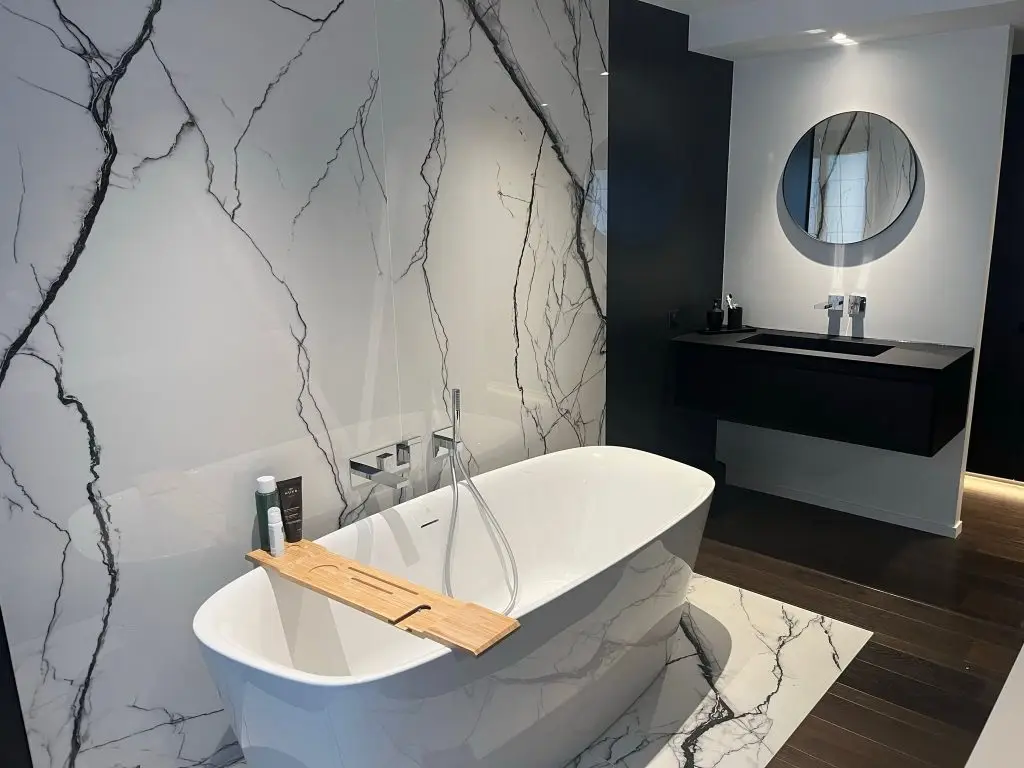 Baignoire îlot devant un mur effet marbre, salle de bain réalisée par JLS Bâtiment