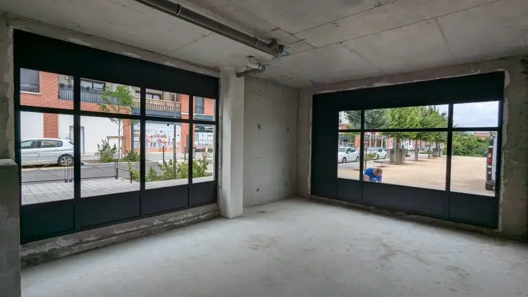 Les mêmes vitrines vues de l'intérieur du local, ouvertes sur la rue