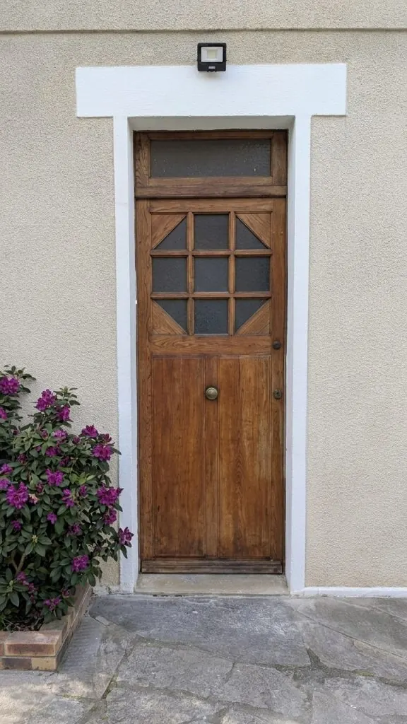 Avant : ancienne porte d'entrée en bois vernis à petits carreaux